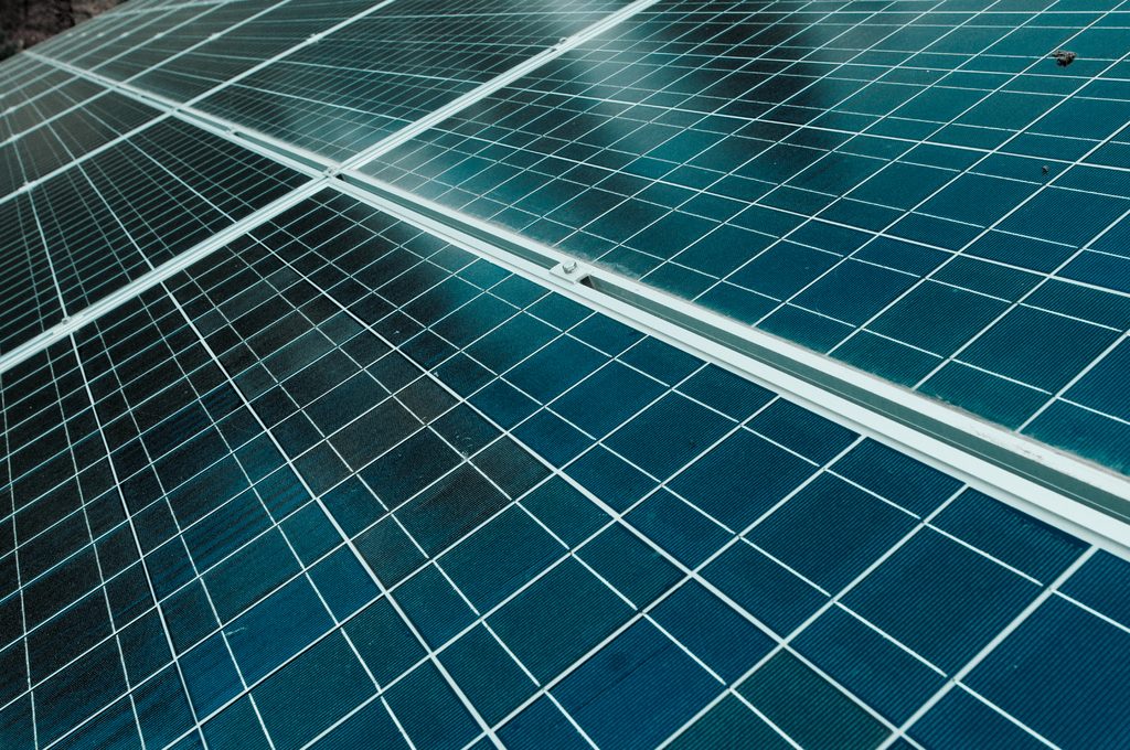 Close view of dark blue solar panels reflecting the sky
